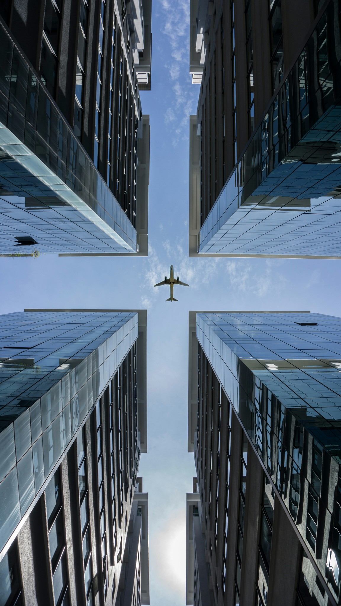 City buildings and an airplane overhead